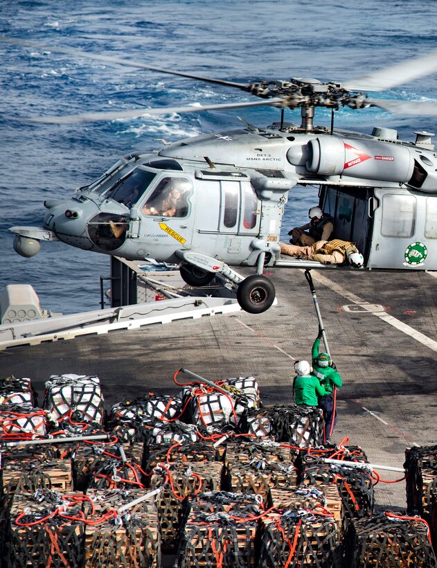 An MH-60S Seahawk helicopter unloads cargo to the flight deck of the aircraft carrier USS Dwight D. Eisenhower during a replenishment with the fast-combat support ship USNS Arctic in the Gulf of Oman, July 20, 2016. The Seahawk is assigned to Helicopter Sea Combat Squadron 7. Navy photo by Petty Officer 2nd Class Ryan U. Kledzik