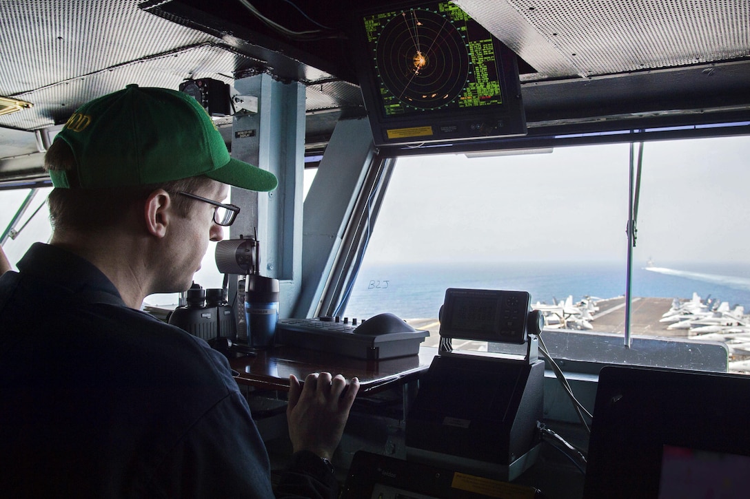 Navy Lt. Shaun Pehl looks out as the junior officer of the deck watch on the bridge of the USS Dwight D. Eisenhower as the aircraft carrier transits through the Strait of Hormuz, July 21, 2016. Navy photo by Petty Officer 3rd Class Anderson W. Branch