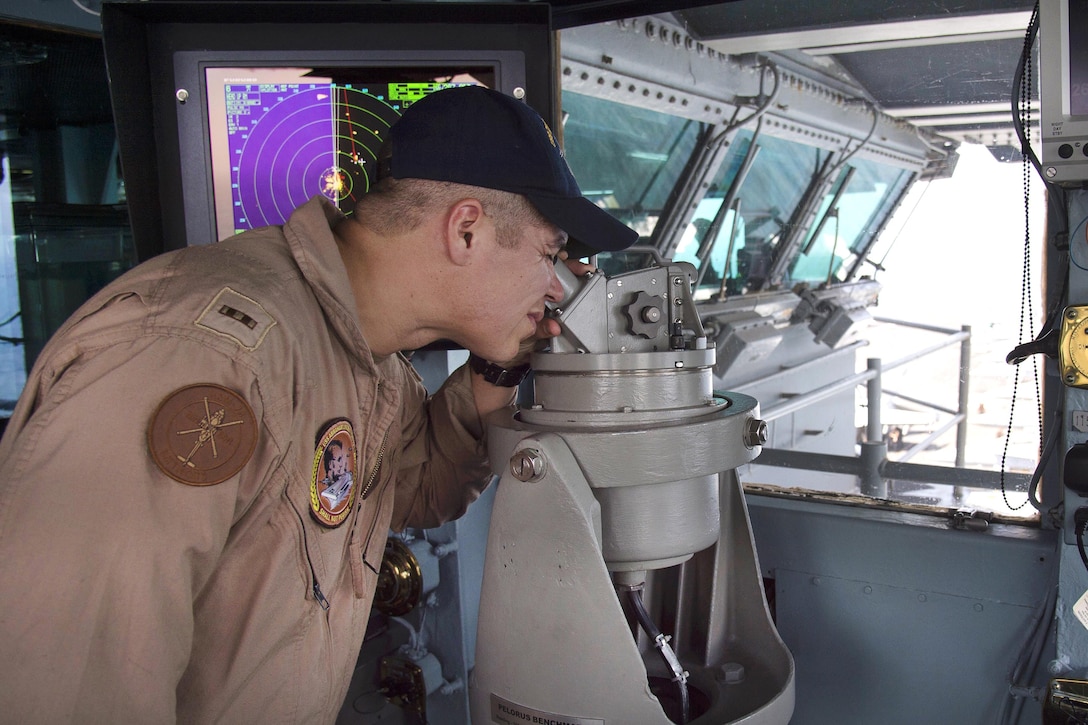 Navy Chief Warrant Officer 2 Quentin Myrick looks through a telescopic alidade, a sighting device, in the auxiliary conning station of the aircraft carrier USS Dwight D. Eisenhower in the Strait of Hormuz, July 21, 2016. Navy photo by Petty Officer 3rd Class Anderson W. Branch