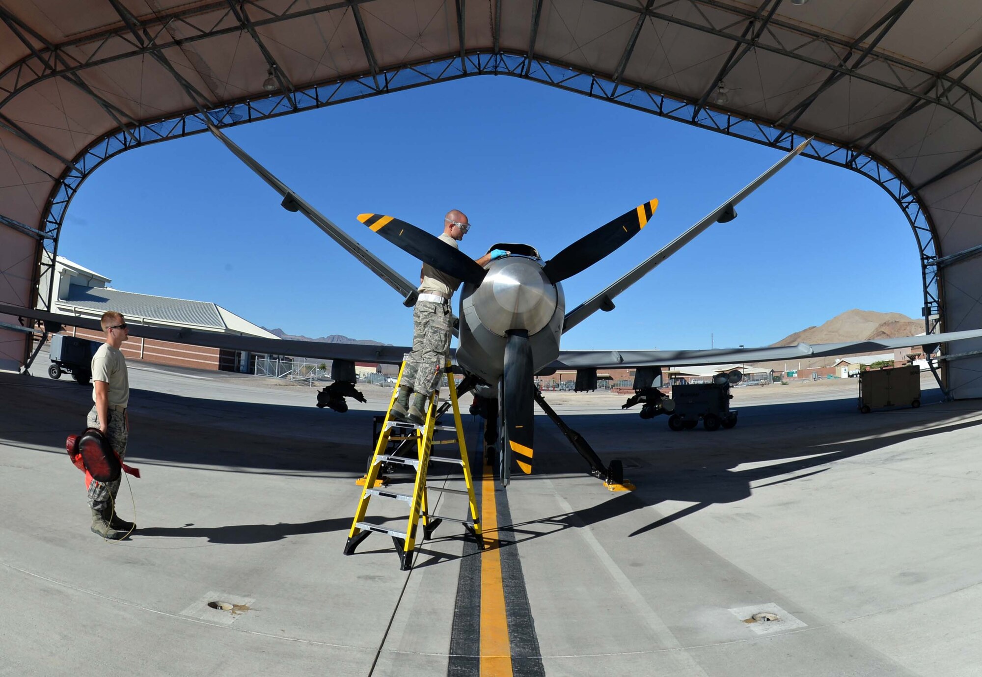 Airman 1st Class Shawn and Airman 1st Class Cole, 432nd Aircraft Maintenance Squadron crew chiefs, inspect an MQ-9 Reaper in preparation for Red Flag 16-3 July 20, 2016, at Creech Air Force Base, Nevada. Red Flag 16-3 incorporates more than 100 aircraft from joint and coalition units that train together on various combat scenarios. (U.S. Air Force photo by Airman 1st Class Kristan Campbell/Released)