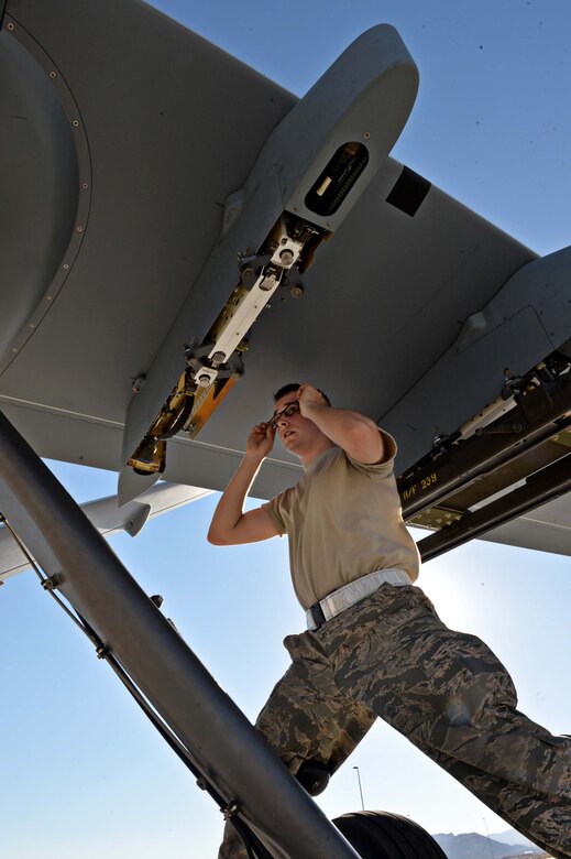 Airman 1st Class Zachary, 432nd Aircraft Maintenance Squadron weapons load crew member, inspects a munitions pylon in preparation for Red Flag 16-3 July 20, 2016, at Creech Air Force Base, Nevada. Airmen from the 432nd Wing/432nd Air Expeditionary Wing fly, maintain and support both the MQ-1 Predators and MQ-9 Reapers in Red Flag operations. (U.S. Air Force photo by Airman 1st Class Kristan Campbell/Released)