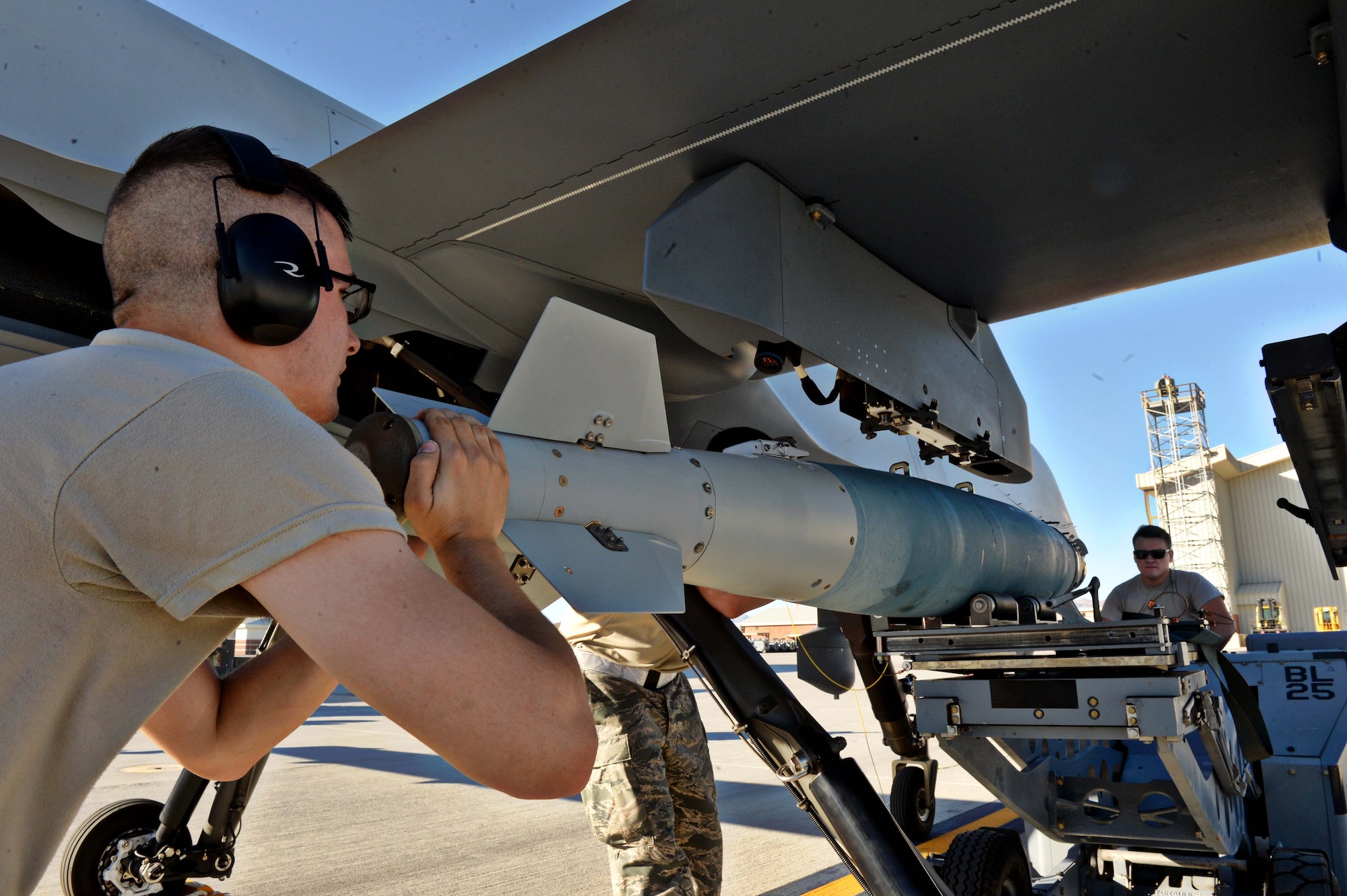 Airmen assigned to the 432nd Aircraft Maintenance Squadron weapons crew load an inert munition on an MQ-9 Reaper weapons pylon in support of Red Flag 16-3 July 20, 2016, at Creech Air Force Base, Nevada. Airmen from the 432nd Wing/432nd Air Expeditionary Wing fly, maintain and support both the MQ-1 Predators and MQ-9 Reapers in Red Flag operations. (U.S. Air Force photo by Airman 1st Class Kristan Campbell/Released)