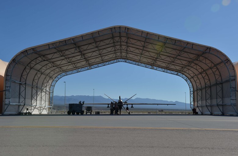 Airmen from the 432nd Aircraft Maintenance Squadron perform maintenance on an MQ-9 Reaper in preparation for Red Flag 16-3 July 20, 2016, at Creech Air Force Base, Nevada. The exercise incorporates a wide range of training scenarios for air, space and cyber systems which are critical to mission success. (U.S. Air Force photo by Airman 1st Class Kristan Campbell/Released)