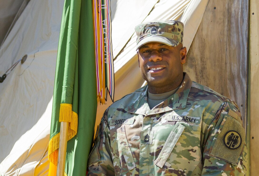 U.S. Army Reserve Sgt. 1st Class Shawn Lee Screen, the mobilization noncommissioned officer in charge at the 11th MP Brigade, poses in front of a tactical operations center July 18 during Warrior Exercise 86-16-03 at Fort McCoy, Wisc. Screen, who lives in Temecula, Calif., saved the life of a civilian who was choking while he was at lunch with a contingent of MPs from Taiwan July 17 in The Dells, Wisc. (U.S. Army Photo by Sgt. 1st Class Jacob Boyer)