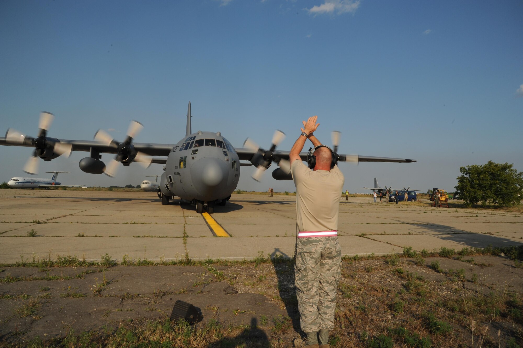 Chief Master Sgt. Leon Alexander directs the aircraft to stop in its parking place on arrival at Otopeni Air Base, Romania.  Otopeni is located on the outskirts of Bucharest.