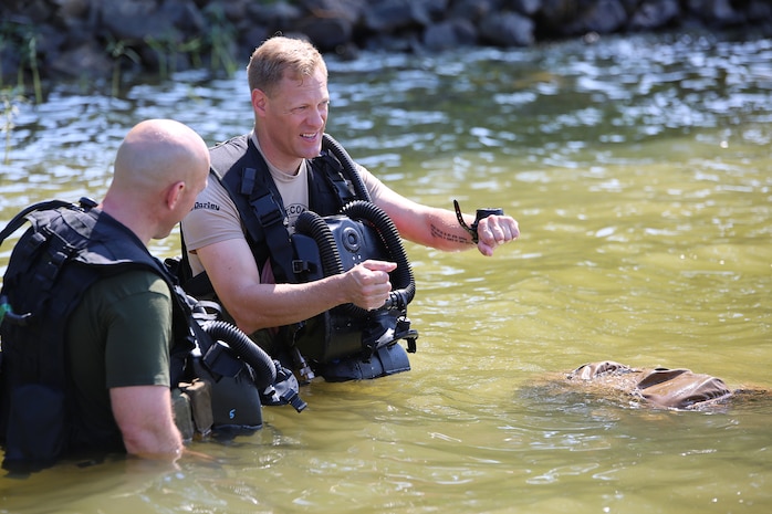 Master Sgt. Brad Colbert, project officer for small craft and special projects with Reconnaissance and Amphibious Raids at Marine Corps Systems Command, describes the dive course to a Marine diver July 18 at Lake Anna in Spotsylvania, Va. Colbert and other members of the RAR team worked with several local Marine combatant divers to conduct tests of potential upgrades to the Diver Propulsion Device to improve its speed and controllability. (U.S. Marine Corps photo by Monique Randolph)