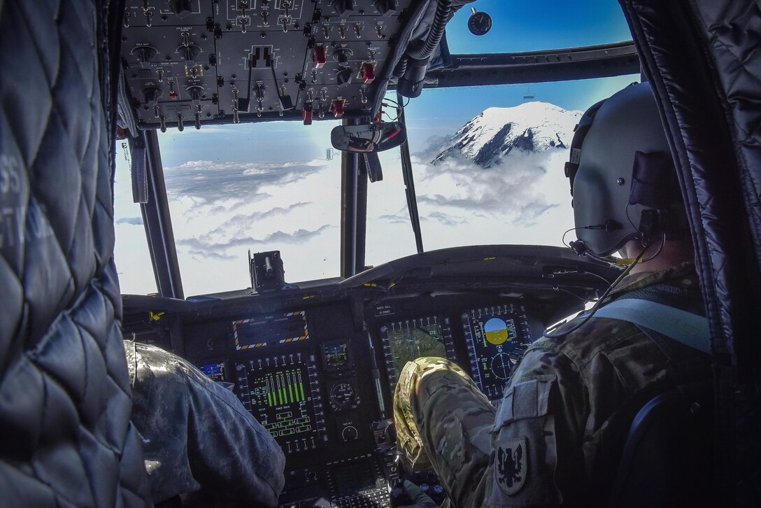 U.S. Army Reserve Chief Warrant Officer 3 Brian Pavlik, 1-214th General Support Aviation Battalion, Bravo Company, keeps a watchful eye during a flyover near Mount Rainier, Wash., onboard a CH-47 Chinook, July 22, 2016.  The 1-214th GSAB, has a unique mission which involves working with the Washington National Park  and provides support for search and rescue missions as well as fire rescue missions in the area.  (U.S. Army photo by Master Sgt. Marisol Walker/Released)