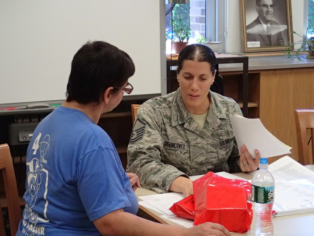 Master Sgt. Andrea DeVincentz, an aerospace medical technician from the 17th Medical Group, Egg Harbor Township, N.J., provides a community member information for continuation of care during Greater Chenango Cares, July 23, 2016.  Greater Chenango Cares is one of the Innovative Readiness Training events which provides real-world training in a joint civil-military environment while delivering world-class medical care to the people of Chenango County, N.Y., from July 15-24.
