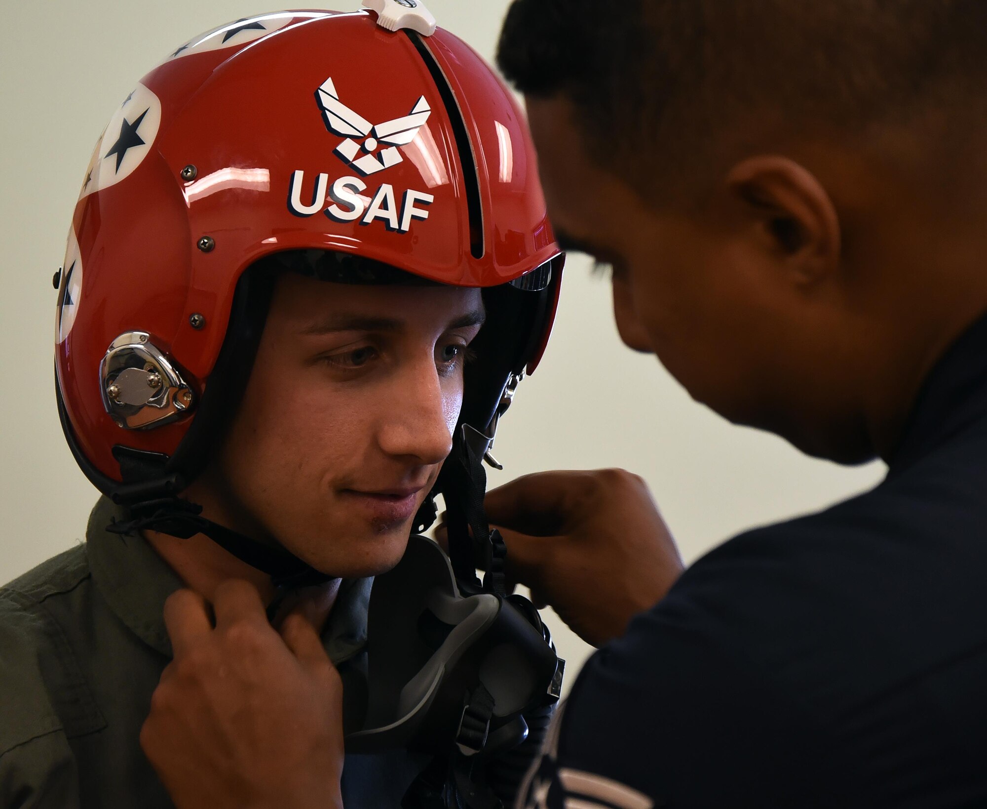 Tech. Sgt. Paul Rosales, U.S. Air Force Thunderbirds aircrew flight equipment specialist, adjusts helmet straps for Sage Kimzey, championship bull rider, July 25, 2016, on the Wyoming Air National Guard Base, Cheyenne, Wyo. Once suited, Kimzey was given an hour long flight complete with barrel rolls, loops and low-altitude maneuvers in an F-16 Fighting Falcon. (U.S. Air Force photo by Senior Airman Brandon Valle)