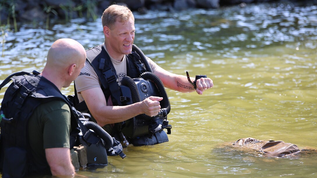 Master Sgt. Brad Colbert, project officer for small craft and special projects with Reconnaissance and Amphibious Raids at Marine Corps Systems Command, describes the dive course to a Marine diver July 18 at Lake Anna in Spotsylvania, Virginia. Colbert and other members of the RAR team worked with several local Marine combatant divers to conduct tests of potential upgrades to the Diver Propulsion Device to improve its speed and controllability.