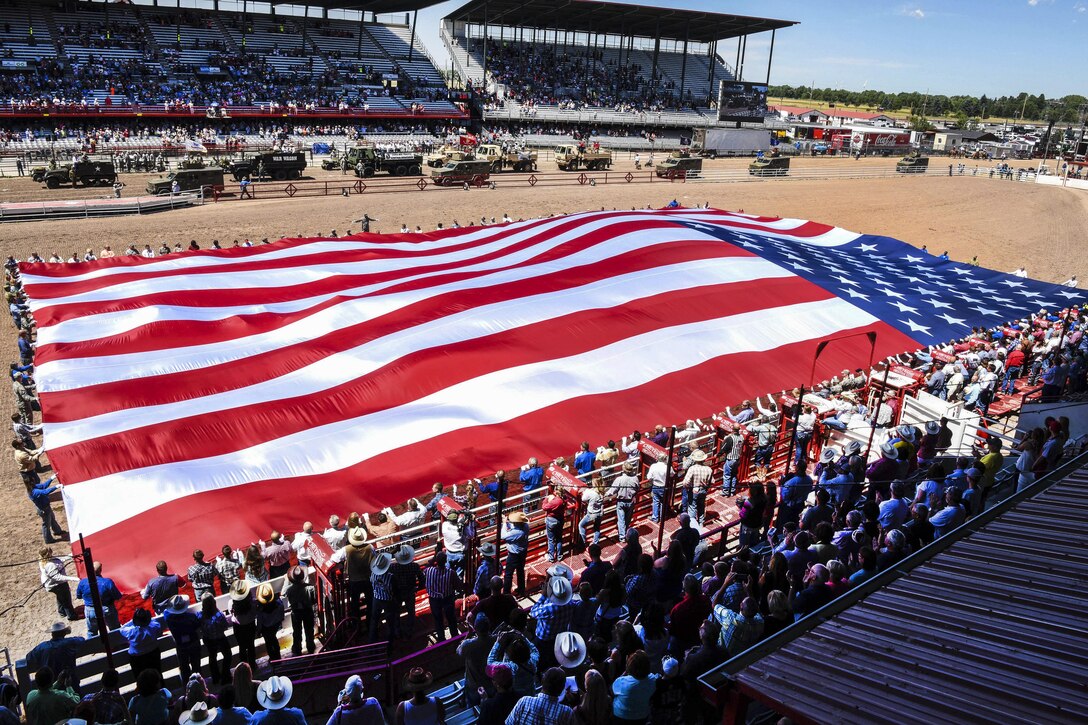 Service members and community volunteers unravel the American flag at Frontier Park in Cheyenne, Wyo., July 25, 2016. More than 200 volunteers participated in this year’s Military Monday event. Air Force photo by Airman 1st Class Breanna Carter