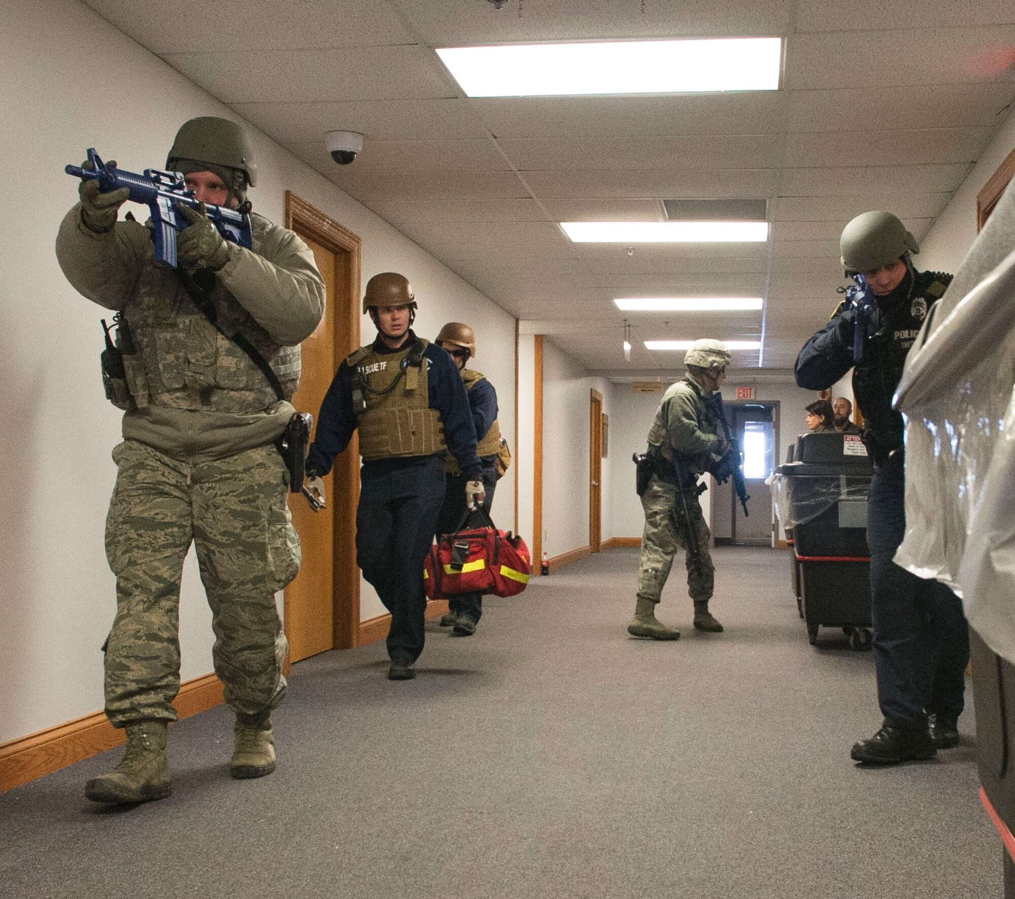 Wright-Patterson AFB defenders and emergency response personnel enter a base facility during a February 2015 active shooter exercise. Active shooter response, deployment operations and other scenarios are planned for the upcoming August exercise which will see Wright-Patt members evaluated on their responses to these events. (U.S. Air Force photo/Wesley Farnsworth)