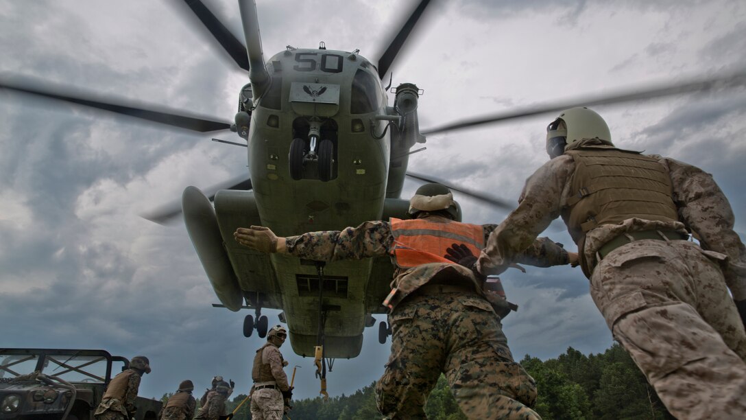 A U.S. Marine assigned to Logistics Operations School, Marine Corps Combat Service Support Schools, uses hand and arm signals to direct the flight path of a CH-53E Super Stallion during a Helicopter Support Team exercise at Camp Lejeune, North Carolina, July 19, 2016. Students attending LOS performed HST exercises as part of their required entry-level training. 