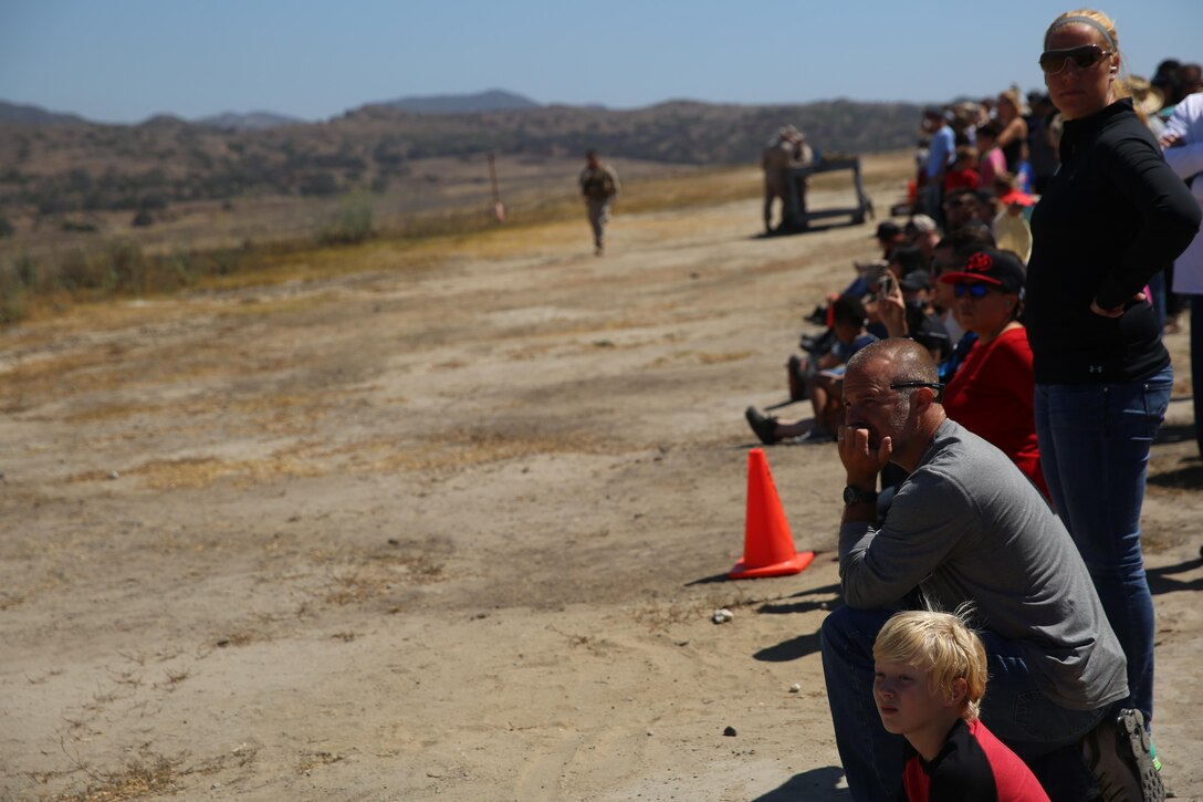 Marines and their family members position themselves behind cones during the helicopter gun run during a Jane Wayne Day event on Camp Pendleton, Calif., July 16, 2016. Pilots with Marine Light Attack Helicopter Training Squadron 303 shot rockets and ammunition at various targets from one UH-1Y Huey helicopter, two AH-1W Cobra helicopters and one AH-1Z Cobra helicopter. (U.S. Marine Corps photo by Lance Cpl. Shellie Hall)