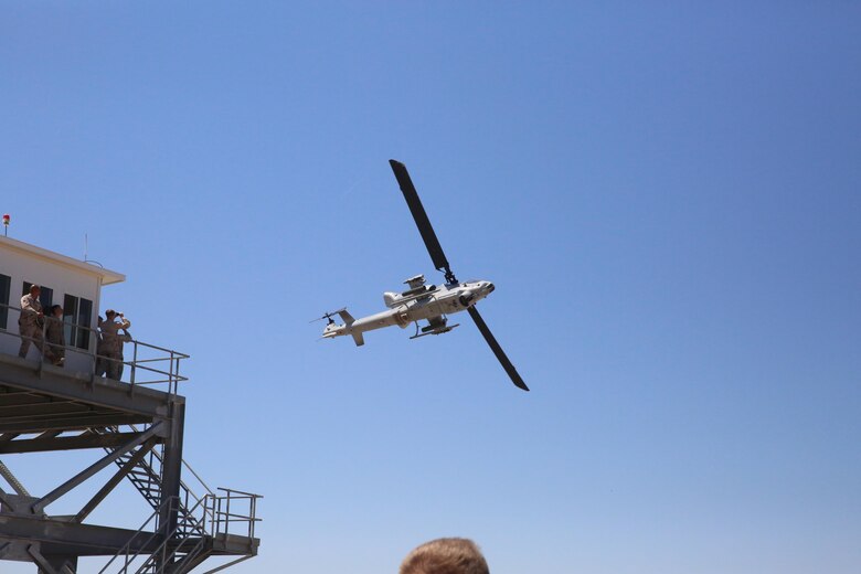 A AH-1W Cobra helicopter flies above the audience during the helicopter gun run during a Jane Wayne Day event on Camp Pendleton, Calif., July 16, 2016. The Jane Wayne Day event gives Marines and their families a chance to bond while becoming familiar with what the Marines experience through hands-on events and live fire exercises. (U.S. Marine Corps photo by Lance Cpl. Shellie Hall)