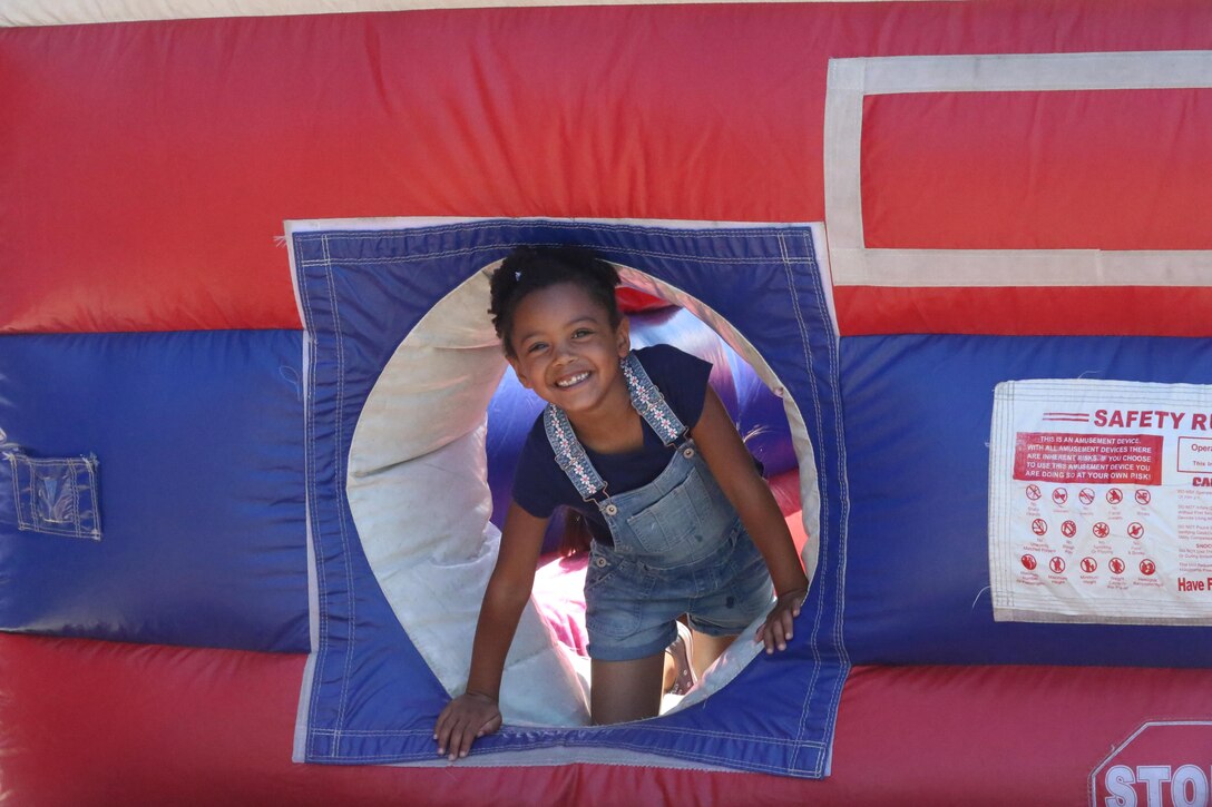 A girl plays in a bounce house during a Jane Wayne Day event on Camp Pendleton, Calif., July 16, 2016. The event included multiple live fire exercises, static displays of vehicles and helicopters, and a barbecue. (U.S. Marine Corps photo by Lance Cpl. Shellie Hall)