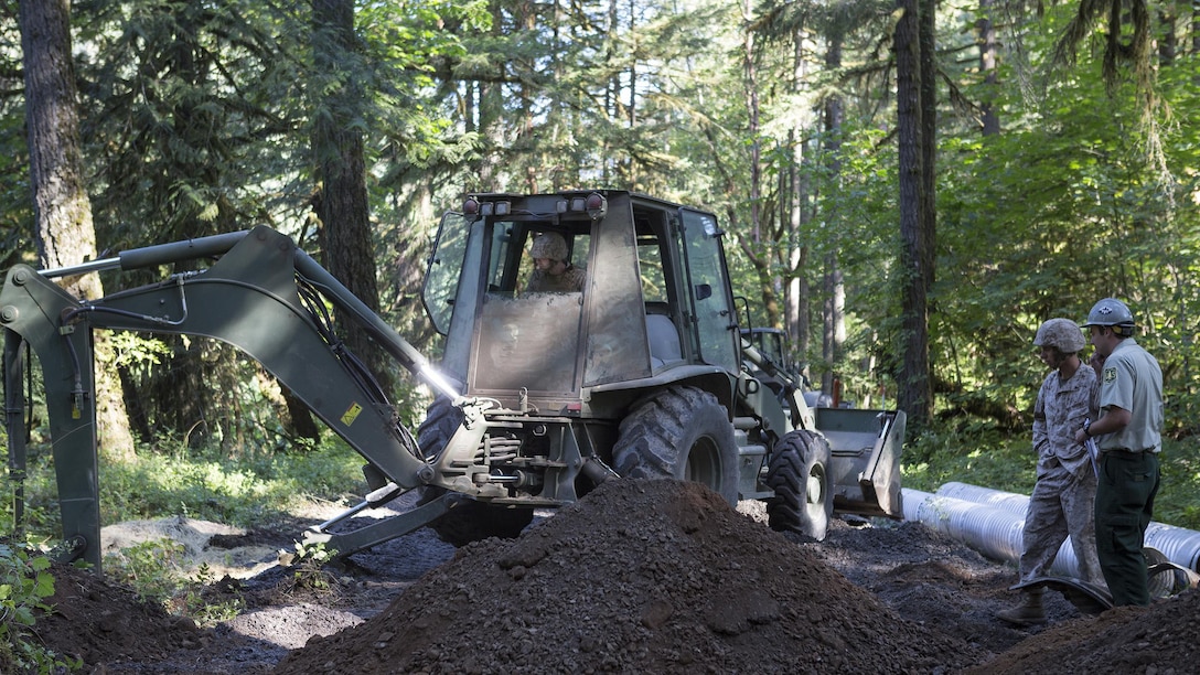Marines with Engineer Services Company, Combat Logistics Battalion 23, Combat Logistics Regiment 4, 4th Marine Logistics Group, Marine Forces Reserve, work with the U.S. Forest Service during Exercise Forest Rattler to clean and repair culverts in roads running through the Willamette National Forest in Oakridge, Oregon, July 21, 2016. The exercise not only allowed the Marines to give back to the community by repairing roads they utilize, but gave them time to hone their skills as an engineering service company.