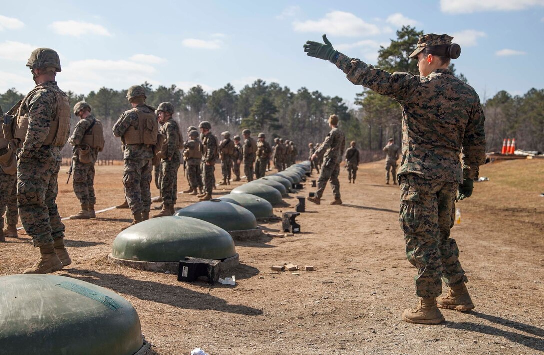 U.S. Marine Corps Lance Cpl. Hirzel, a member of the female engagement team with 22nd Marine Expeditionary Unit (MEU), raises her hand to signify that all Marines are ready during a combat marksmanship exercise at Fort Pickett, Va., Feb. 18, 2016. Marines with 22nd MEU conducted the range as a part of their predeployment training and in preparation for a future deployment.