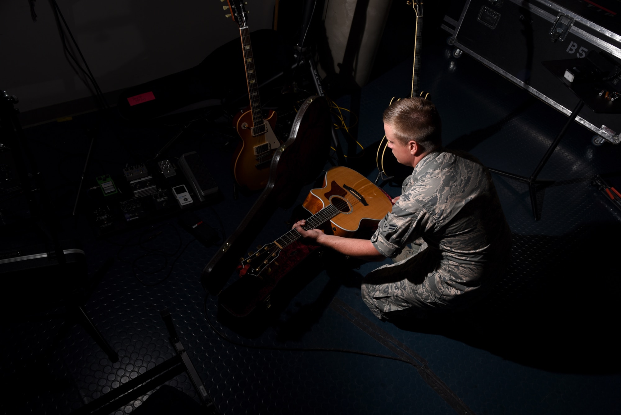 Airman 1st Class Jamie Teachenor, U.S. Air Force Academy Band and Wild Blue Country lead vocalist, removes his acoustic guitar from its case at Peterson Air Force Base, Colo., on July 20, 2016. Teachenor performs most of his songs while playing either the piano or the guitar. (U.S. Air Force photo by Airman 1st Class Dennis Hoffman)