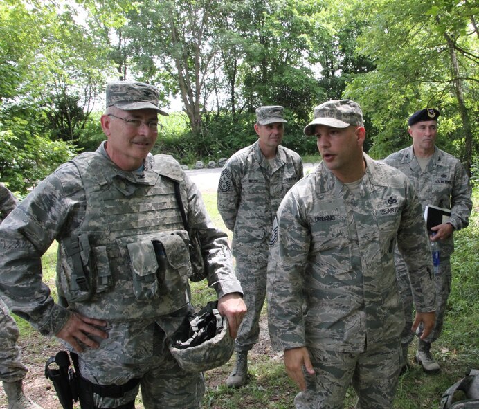 Commander of the 932nd Airlift Wing, Col. Jonathan Philebaum, gets a situational awareness briefing from Master Sgt. Salvatore Urbano, with the 932nd Security Forces Squadron, before putting on his helmet of protection and moving deeper into the forest to execute the mission as part of a four person team  The SFS squads spent a hot weekend in the woods shooting at targets, moving as a team, and performing low crawls during a portion of the combat physical exercise course.  It was held during the July unit training assembly, July 9-10, 2016, Scott Air Force Base, Illinois. SFS had members flip a tire, low crawl, run with fuel cans filled with water, perform a first aid fireman carry to lift and move a fellow Airman and then drag them a set distance, all while sprinting between stations.  (U. S. Air Force photo by Maj. Stan Paregien)