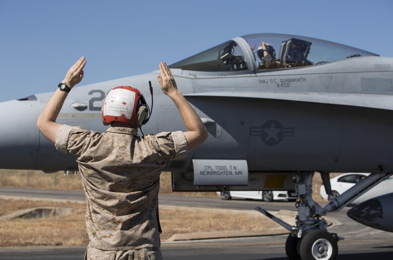 Cpl. Matthew Sisk, an ordnance Marine with Marine Fighter Attack Squadron (VMFA) 122, guides an F/A 18C Hornet with VMFA-122 to a halt for inspection at Royal Australian Air Force Base Tindal, Australia, July 22, 2016. VMFA-122 traveled to RAAF Base Tindal for the first time for exercises Southern Frontier Unit Level Training and Pitch Black 16. Southern Frontier ULT will help the squadron gain experience and qualifications in low altitude, air ground, high explosive ordnance delivery at the unit level. Pitch Black 16 affords Marines with VMFA-122 the opportunity to integrate and increase interoperability with regional joint and coalition partners while developing operational concepts for conducting sustained combat operations.  (U.S. Marine Corps photo by Cpl. Nicole Zurbrugg)