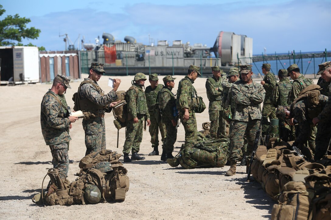1st Lt. Josh Cuyler, far left, and Sgt. Dalton K. Anonsen gather subordinate Marines with 2nd Battalion, 3rd  Marine Regiment and attached members of the Japanese Ground Self Defense Force at Kawaihae Pier, Hawaii, July 15, 2016, to account for personnel and equipment after an amphibious offload from USS San Diego. The Marines are participating in Rim of the Pacific 2016, a multinational military exercise, from June 29 to Aug. 4 in and around the Hawaiian Islands. RIMPAC 16 is a complex amphibious exercise involving numerous to ship-to-shore movements that require careful attention to detail from Marines and sailors throughout the echelons of command. Cuyler, a native of Rochester, New York, is a platoon commander with Echo Company. Anonsen, from Waldorf, Maryland, is Cuyler’s acting platoon sergeant. 