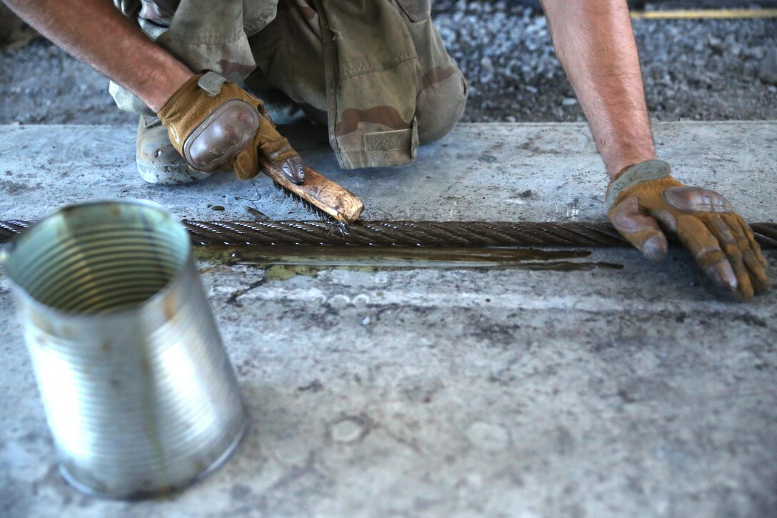 Sgt. James Monroe removes rust from a winch cable at Pohakuloa Training Area, Hawaii, July 17, 2016. Monroe is participating in Rim of the Pacific 2016, a multinational exercise, from June 29 to Aug. 8 in and around the Hawaiian Islands. During RIMPAC, motor transportation mechanics are responsible for ensuring the safety and operability of Marine Wing Support Squadron 171’s ground vehicles, in order to support integrated air-ground events during the exercise. Monroe, a native of Lyons, Georgia, is the motor transportation quality control chief for MWSS-171, Marine Aircraft Group 12, which supports III Marine Expeditionary Force. (U.S. Marine Corps Photo by Cpl. Natalie A. Dillon)