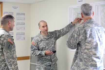 Army Reserve Maj. Damien Squilla, center, Battalion Executive Officer, 1st Battalion, 383rd Regiment, 181st Infantry Brigade, gives Col. Robert Cooley, deputy commander for the 85th Support Command, a brief on operations conducted at Warrior Exercise 86-16-03, Fort McCoy, Wisconsin, July 11, 2016.
(U.S. Army photo by Mr. Anthony L. Taylor/Released)