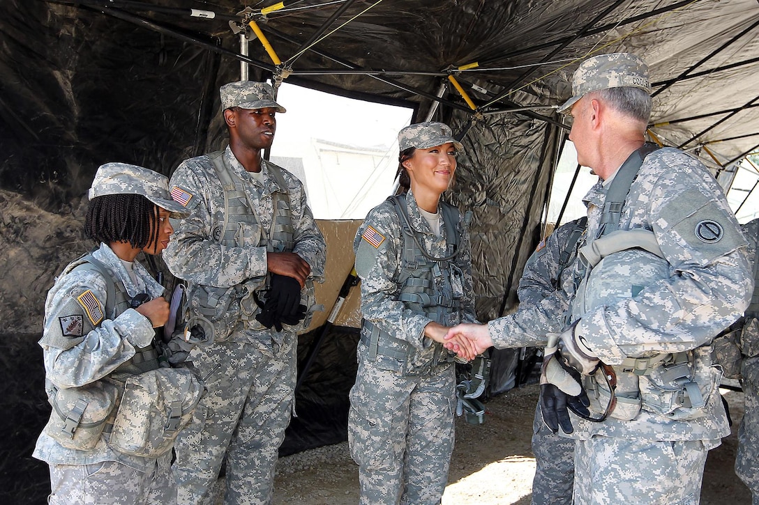 Col. Robert Cooley, right, deputy commander of the 85th Support Command, shakes hands with 2nd Lt. Stephanie Brooks, 1-383 training support battalion, 181st Infantry Brigade, during a meet with observer-coach/trainers at forward operating (training) base Justice, Fort McCoy, Wisconsin, July 11, 2016.
(U.S. Army photo by Mr. Anthony L. Taylor/Released)