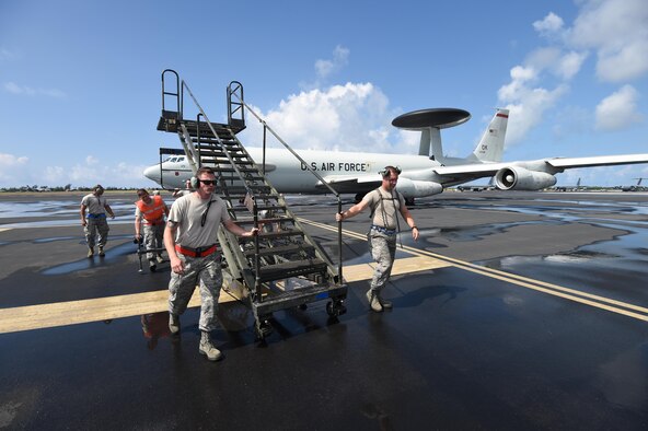 U.S. Airmen assigned to the 513th Aircraft Maintenance Squadron, roll stairs away from an E-3 Sentry at Joint Base Pearl Harbor-Hickam, Hawaii, July 19, 2016. More than 125 Airmen with the 513th Air Control Group and 552nd Air Control Wing are deployed to Hawaii from Tinker Air Force Base, Okla., in support of the Rim of the Pacific (RIMPAC) 2016 exercise. Twenty-six nations, more than 40 ships and submarines, more than 200 aircraft and 25,000 personnel are participating in RIMPAC from June 30 to Aug. 4, in and around the Hawaiian Islands and Southern California. The world's largest international maritime exercise, RIMPAC provides a unique training opportunity that helps participants foster and sustain the cooperative relationships that are critical to ensuring the safety of sea lanes and security on the world's oceans. RIMPAC 2016 is the 25th exercise in the series that began in 1971. (U.S. Air Force photo by 2nd Lt. Caleb Wanzer)
