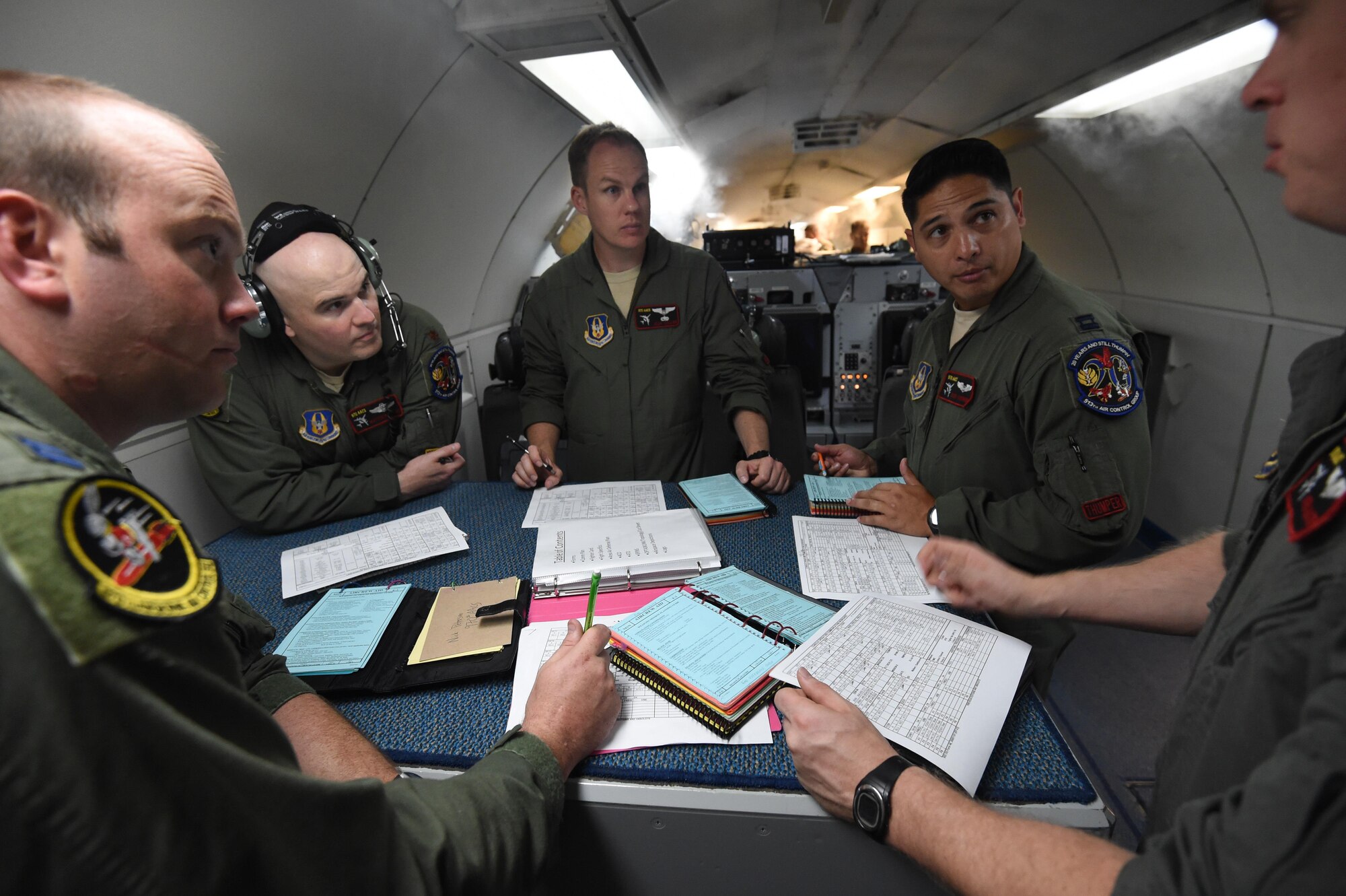 Air battle managers assigned to the 970th Airborne Air Control Squadron discuss mission details on July 23, 2016, aboard an E-3 Sentry at Joint Base Pearl Harbor-Hickam, Hawaii, prior to a mission in support of Rim of the Pacific 2016. More than 125 Airmen from the 513th Air Control Group and 552nd Air Control Wing are deployed to Hawaii in support of the RIMPAC 2016 exercise. Twenty-six nations, more than 40 ships and submarines, more than 200 aircraft and 25,000 personnel are participating in RIMPAC from June 30 to Aug. 4, in and around the Hawaiian Islands and Southern California. The world's largest international maritime exercise, RIMPAC provides a unique training opportunity that helps participants foster and sustain the cooperative relationships that are critical to ensuring the safety of sea lanes and security on the world's oceans. RIMPAC 2016 is the 25th exercise in the series that began in 1971. (U.S. Air Force photo by 2nd Lt. Caleb Wanzer)