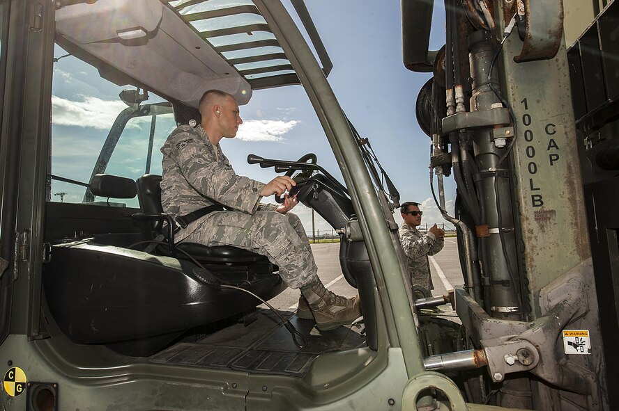 U.S. Air Force Senior Airmen Robert Barlow and Victor Covarrubias-Ruiz, 18th Logistics Readiness Squadron cargo deployment function journeymen, raise a cargo container for inspection July 20, 2016, at Kadena Air Base, Japan. The cargo deployment function team need to be on their toes as cargo can come to them with a less than 20 minute notification. (U.S. Air Force photo by Airman 1st Class Corey M. Pettis)