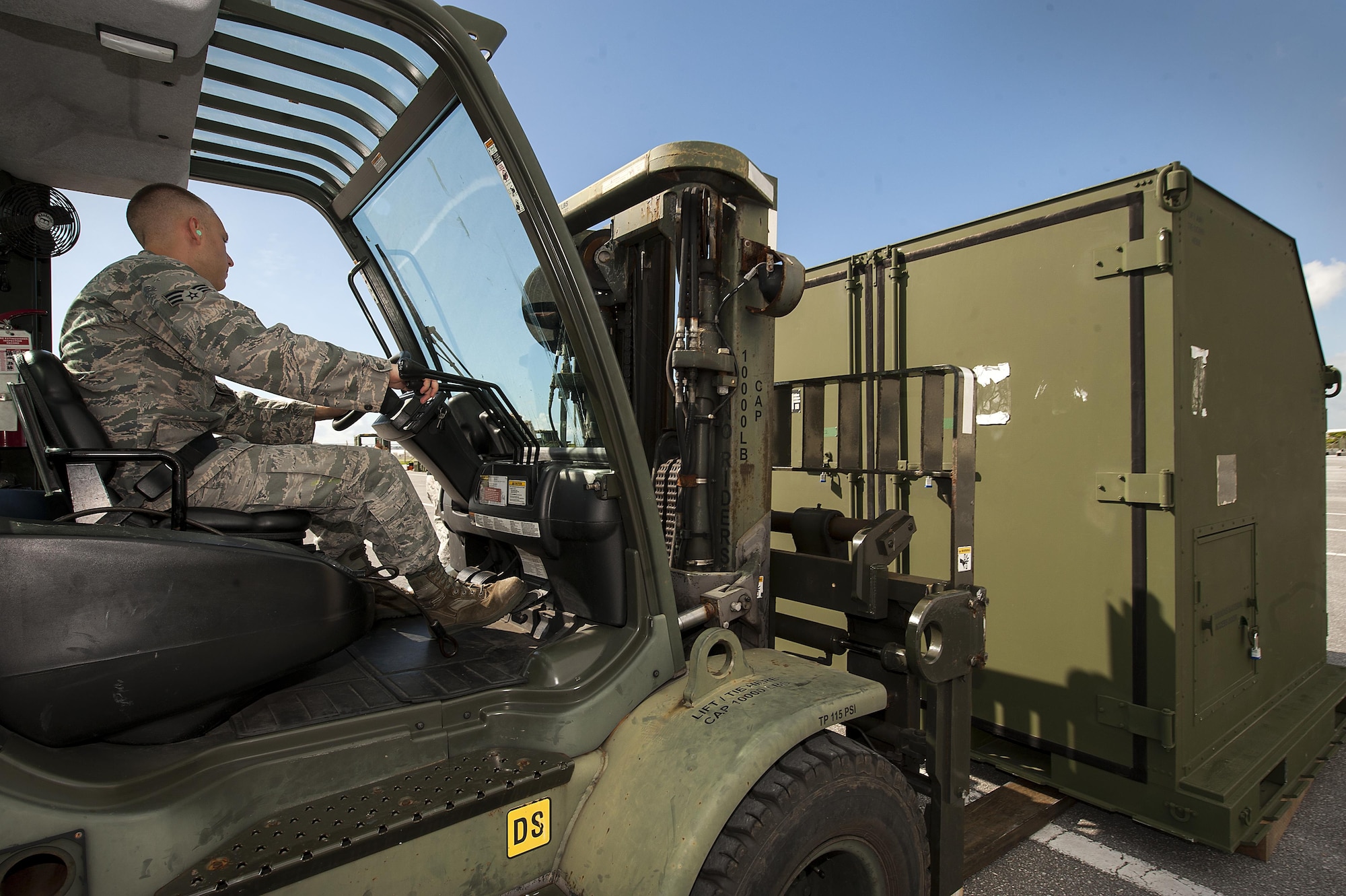 U.S. Air Force Senior Airman Robert Barlow, 18th Logistics Readiness Squadron cargo deployment function journeyman, raises a cargo container for inspection July 20, 2016, at Kadena Air Base, Japan. The cargo deployment function supervises the inspecting, handling and loading of cargo. (U.S. Air Force photo by Airman 1st Class Corey M. Pettis)