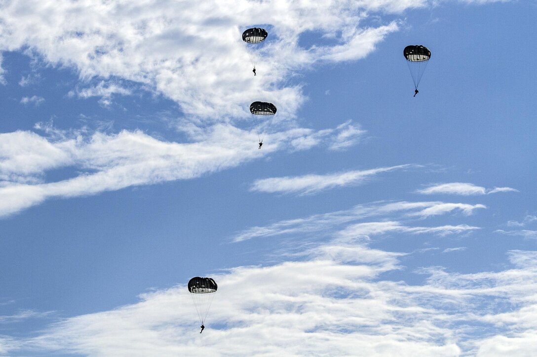 Army Rangers descend with full chutes after parachuting from a CH-47F Chinook helicopter during a water insertion off the coast of Tybee Island, Ga., July 20, 2016. Army photo by Sgt. William Begley