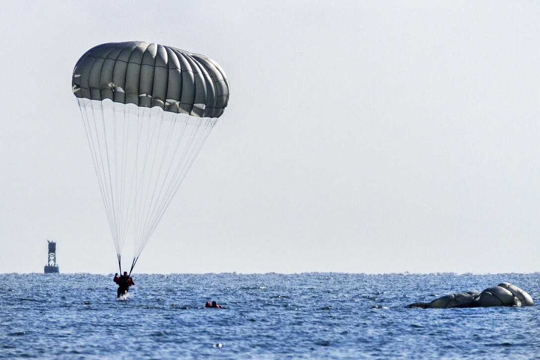 An Army Ranger lands after jumping from a Chinook helicopter during training off the coast of Tybee Island, Ga., July 20, 2016. Army photo by Sgt. William Begley