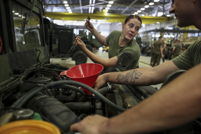 Two Marines with 2nd Maintenance Battalion work together to check the oil in a Humvee as part of a maintenance check at Camp Lejeune, N.C., July 21, 2016. 2nd Maint. Bn. was recently recognized for their abilities as a cohesive unit by earning the Chesty Puller Award, the Ground Safety Award and the Department of Defense Maintenance Award. (U.S. Marine Corps photo by Lance Cpl. Miranda Faughn/Released)