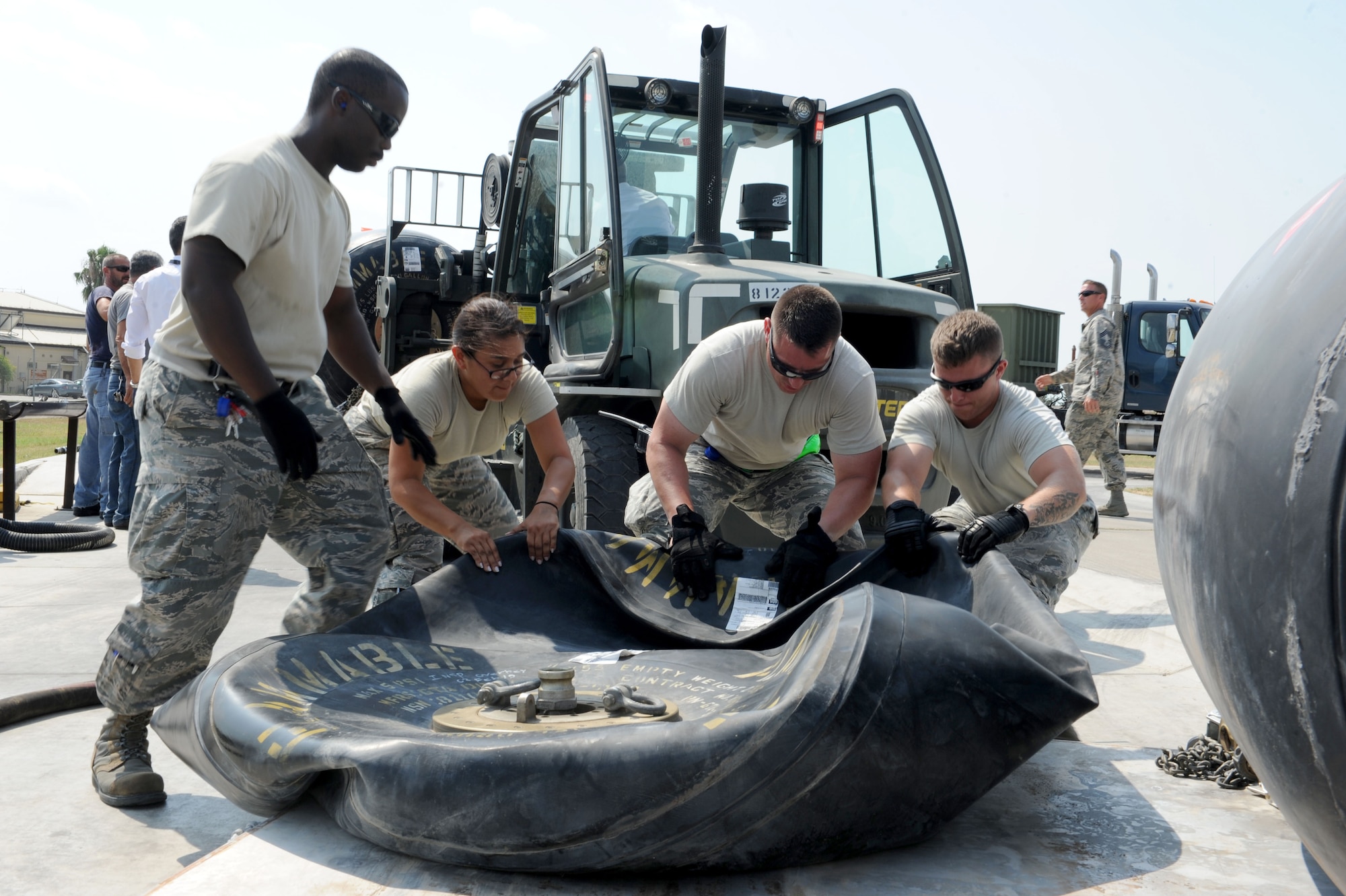 U.S. Air Force Staff Sgt. Brandon Jenkins, (left), Senior Airman Samantha Perez, Tech. Sgt. Tony Otis, and Staff Sgt. Christian Crider, 39th Logistics Readiness Squadron petroleum oils and lubricants flight Airmen, drag a fuel bladder to better allow fuel to flow while unloading into bulk storage July 22, 2016, at Incirlik Air Base, Turkey. Due to an extended loss of commercial power to the base, supplies, including food, water and fuel were delivered to sustain missions here at Incirlik. (U.S. Air Force photo by Staff Sgt. Jack Sanders)
