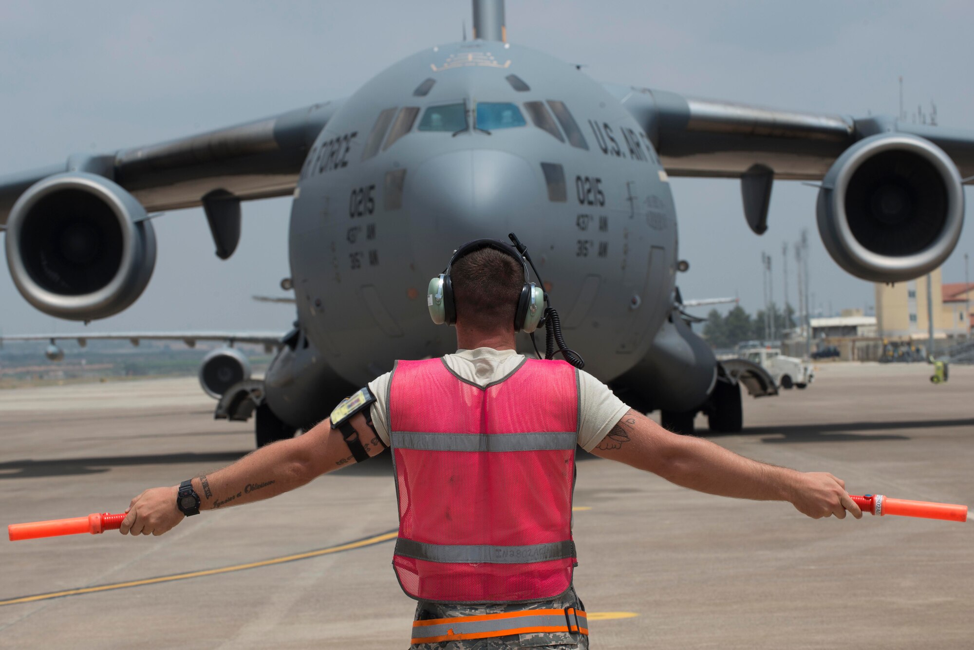 An Airman from the 728th Air Mobility Squadron marshals in a C-17 Globemaster III July 22, 2016, at Incirlik Air Base Turkey. The C-17 carried fuel bladders that were distributed for operations at Incirlik Air Base. (U.S. Air Force photo by Senior Airman John Nieves Camacho)