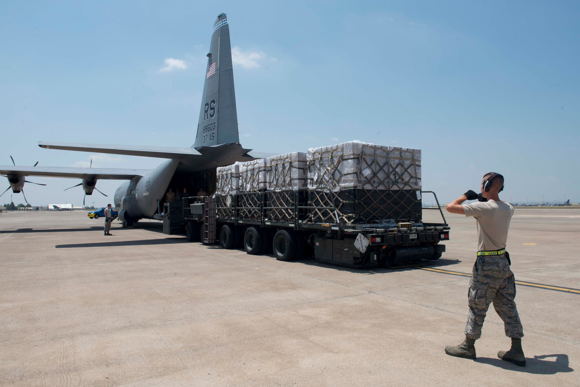 An Airman from the 728th Air Mobility Squadron guides a truck back July 22, 2016, at Incirlik Air Base Turkey. The truck contained cargo received from a C-130J Super Hercules aircraft. (U.S. Air Force photo by Senior Airman John Nieves Camacho)