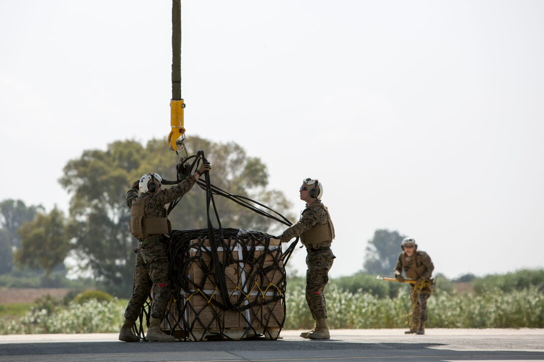 Landing support specialists with Combat Logistics Battalion 2, Special Purpose Marine Air-Ground Task Force-Crisis Response-Africa, attach a 1,098 pound pallet of Meals, Ready to Eat to an MV-22B Osprey during a helicopter support team exercise aboard Naval Station Rota, Spain, July 6, 2016. The HST training was conducted to increase proficiencies in logistics tasks and to enhance the ability to execute potential contingency missions. (U.S. Marine Corps photo by Staff Sgt. Tia Nagle/Released)