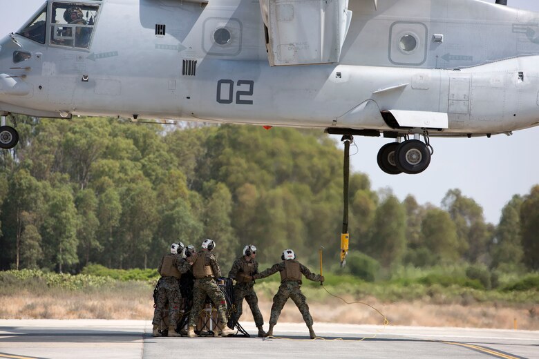 Landing support specialists with Combat Logistics Battalion 2, Special Purpose Marine Air-Ground Task Force-Crisis Response-Africa, prepare to attach a 1,098 pound pallet of Meals, Ready to Eat to an MV-22B Osprey during a helicopter support team exercise aboard Naval Station Rota, Spain, July 6, 2016. The HST training was conducted to increase proficiencies in logistics tasks and to enhance the ability to execute potential contingency missions. (U.S. Marine Corps photo by Staff Sgt. Tia Nagle/Released)