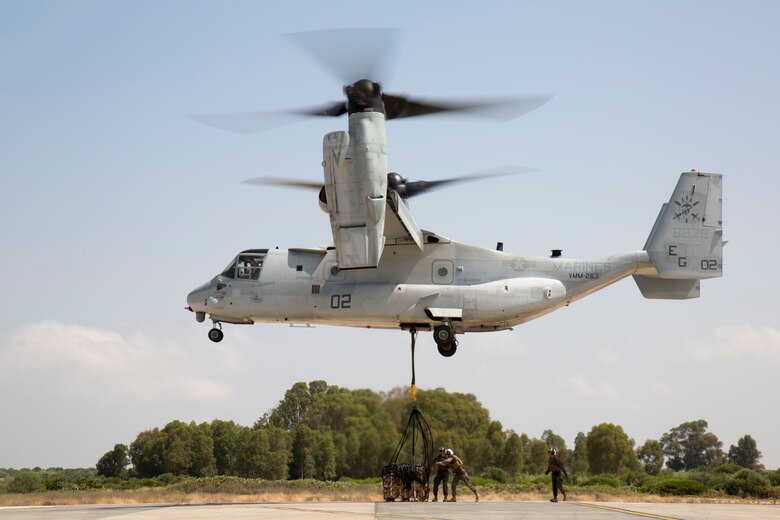 Landing support specialists with Combat Logistics Battalion 2, Special Purpose Marine Air-Ground Task Force-Crisis Response-Africa, attach a 1,098 pound pallet of Meals, Ready to Eat to an MV-22B Osprey during a helicopter support team exercise aboard Naval Station Rota, Spain, July 6, 2016. This training prepares the Marines to efficiently attach cargo to the aircraft and helps qualify air crew in the mission-essential task of rapid insertion and extraction. (U.S. Marine Corps photo by Staff Sgt. Tia Nagle/Released)