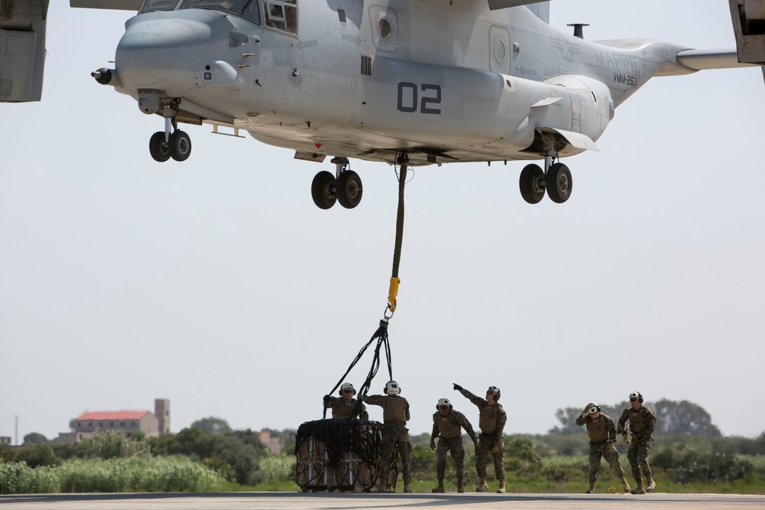 Landing support specialists with Combat Logistics Battalion 2, Special Purpose Marine Air-Ground Task Force-Crisis Response-Africa, attach a 1,098 pound pallet of Meals, Ready to Eat to an MV-22B Osprey during a helicopter support team exercise aboard Naval Station Rota, Spain, July 6, 2016. This training prepares Marines to deliver and recover supplies and equipment quickly and efficiently in potential future missions around Europe and Africa. (U.S. Marine Corps photo by Staff Sgt. Tia Nagle/Released)