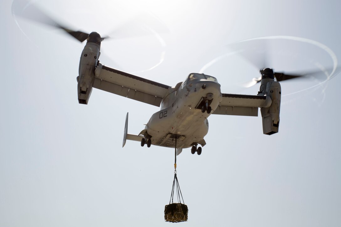 An MV-22B Osprey with Marine Medium Tiltrotor Squadron 263, Special Purpose Marine Air-Ground Task Force-Crisis Response-Africa, transports a 1,098 pound pallet of Meals, Ready to Eat during a helicopter support team exercise aboard Naval Station Rota, Spain, July 6, 2016. External lift training prepares the Marines to efficiently attach cargo to the aircraft and helps qualify air crew in the mission-essential task of rapid insertion and extraction in a possible crisis response scenario. (U.S. Marine Corps photo by Staff Sgt. Tia Nagle/Released)