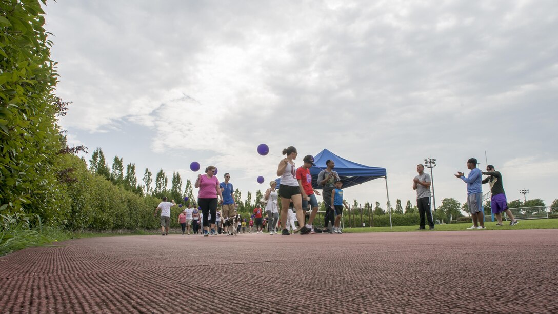 Team Aviano members and local Italians walk around the base track during an American Cancer Society Relay for Life event, July 23, 2016, at Aviano Air Base, Italy. The event lasted 24 hours and gave participants the opportunity to celebrate the lives of cancer survivors and victims, and raise money to fight back against the illness. (U.S. Air Force photo by Airman 1st Class Cory W. Bush/Released)