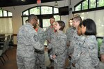 Chief Master Sgt. Troy Palmer (left), 12th Flying Training Wing command chief, coins Airman Alisa Gebert, Air Force Personnel Center, on being the Dorm of the Quarter award recipient July 15 at Joint Base San Antonio-Randolph. The First Sergeants Council's mission is to support and assist Air Force members through all facets of their career, both professional and personal.