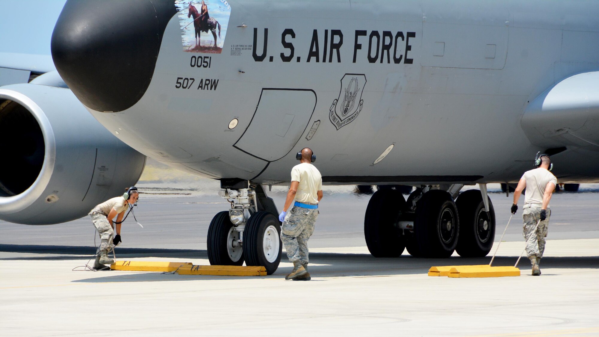 JOINT BASE PEARL HARBOR-HICKAM - U.S. Air Force Senior Airman Nathalie Hamilton and Tech Sgt. Michael Dunning, crew chiefs with the 507th Maintenance Squadron, place wheel chocks on a KC-135R Stratotanker following a refueling mission as part of Rim of the Pacific 2016. (U.S. Air Force photo\Tech. Sgt. Lauren Gleason)