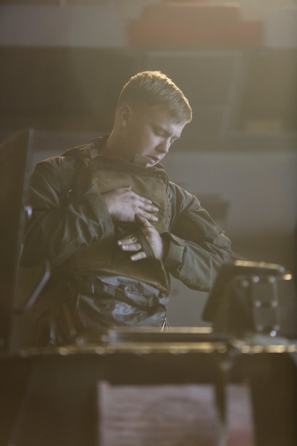 A U.S. Marine with Battalion Landing Team 1/6, 22nd Marine Expeditionary Unit (MEU) puts on protective gear during PHIBRON/MEU Integration Training (PMINT) aboard the USS Whidbey Island (LSD 41), March 20, 2016. PMINT was conducted as part of training required of Marines and Sailors preparing for an upcoming deployment.