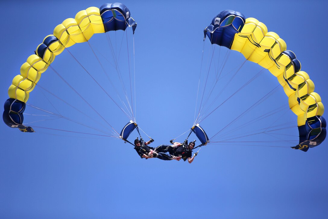 Sailors Brandon Peterson and TJ Amdahl perform the parabatic maneuver known as "bringing up a down plane” during Cheyenne Frontier Days in Cheyenne, Wyo., July 25, 2016. The sailors are members of the Leap Frogs, the Navy's parachute team, which received air support from Wyoming Air National Guard C-130 Hercules aircraft and crews during for event. Army National Guard photo by Sgt. 1st Class Jimmy McGuire
