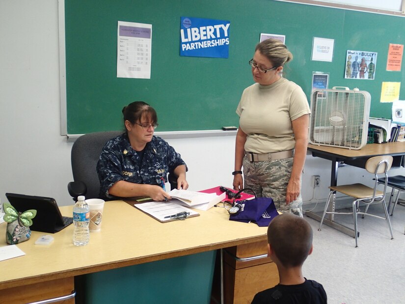 Tech Sgt. Lora “Lori” Olsen, a medical technician with the 174th Medical Group out of Syracuse, N.Y., briefs Lt. Cmdr. Kathleen Cooper, a physician’s assistant with Expeditionary Medical Facility, Bethesda, Md., regarding the patient’s medical history during Greater Chenango Cares, July 24, 2016.  Greater Chenango Cares is one of the Innovative Readiness Training events which provides real-world training in a joint civil-military environment while delivering world-class medical care to the people of Chenango County, N.Y., from July 15-24.